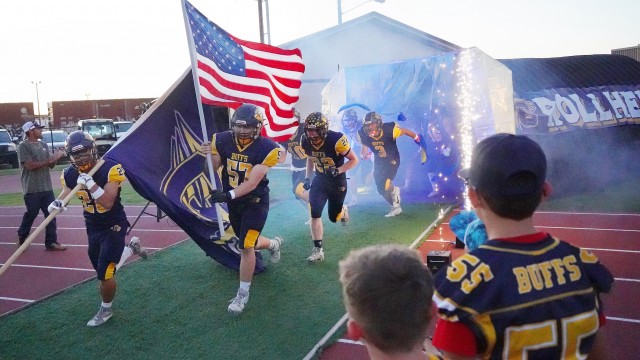 Senior Jesse Brown carries the Buff flag alongside junior Phillip Thomas carrying the American flag as the varsity football team enters the stadium at the start of their homecoming game Friday night. Standing on each side were members of the Greybull Rec District intramural football team and the Greybull Middle School football team. Lisa Kunkel