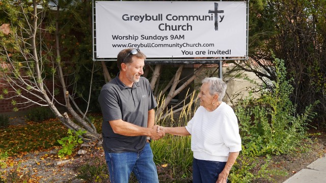 Pastor Aaron Gesch shakes hands with Kay Mattis outside the former Greybull Presbyterian Church on Monday afternoon. Gesch, lead pastor at Basin’s First Baptist Church, is helping Mattis and other church members transition to the new Greybull Community Church. Lisa Kunkel